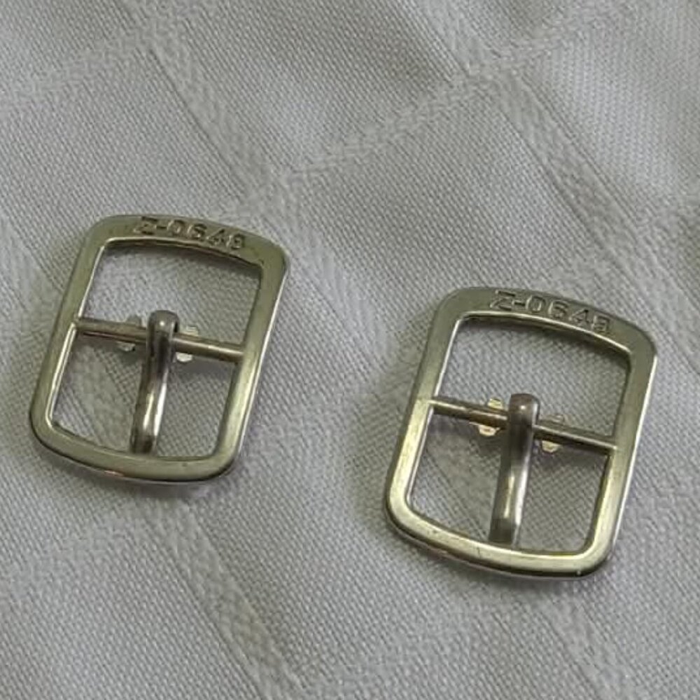 B- Two vintage silver-colored watch buckles